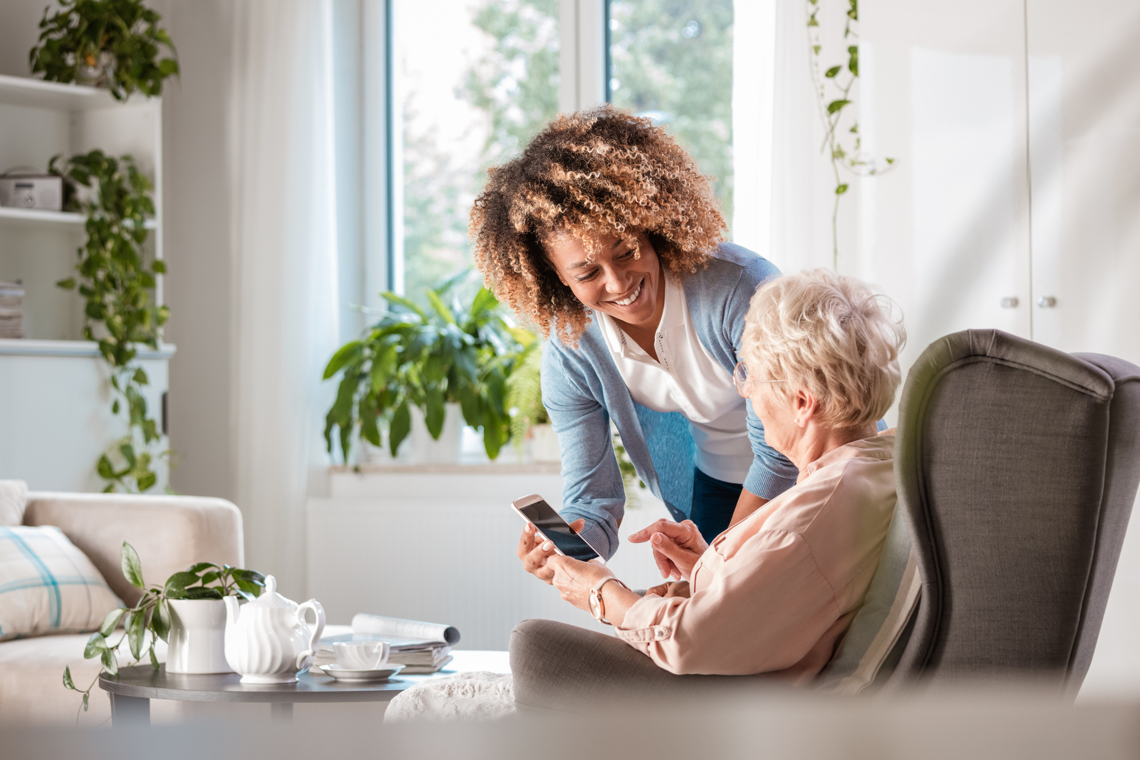 Home caregiver assisting senior woman